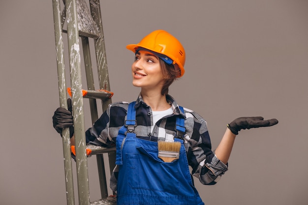 Reparador de mujer con escalera en un uniforme aislado