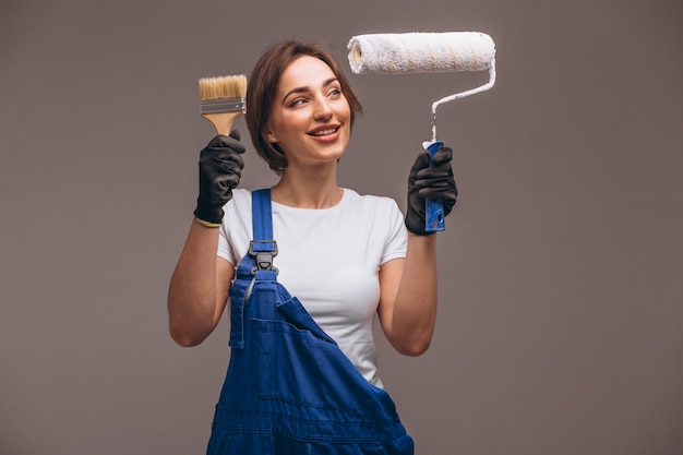 Reparador de mujer con rodillo de pintura aislado