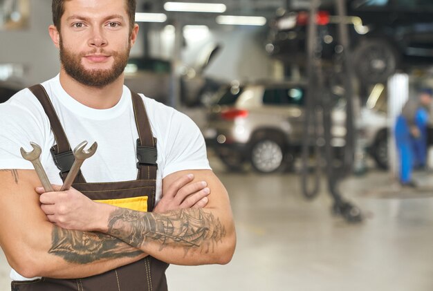 Reparador tatuado y musculoso posando en autoservicio.