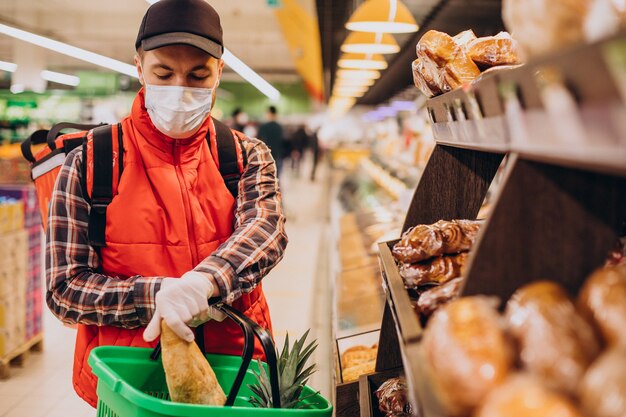 Repartidor de alimentos comprando productos en la tienda de comestibles