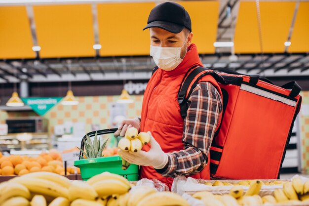 Repartidor de alimentos comprando productos en la tienda de comestibles