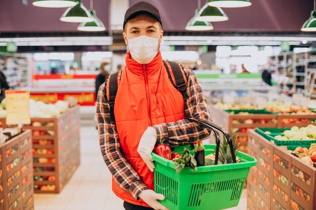 Repartidor de alimentos comprando productos en la tienda de comestibles