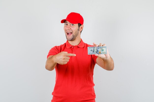 Repartidor apuntando al billete de dólar en camiseta roja