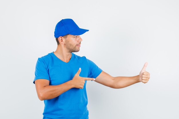 Repartidor apuntando con su pulgar hacia arriba en camiseta azul