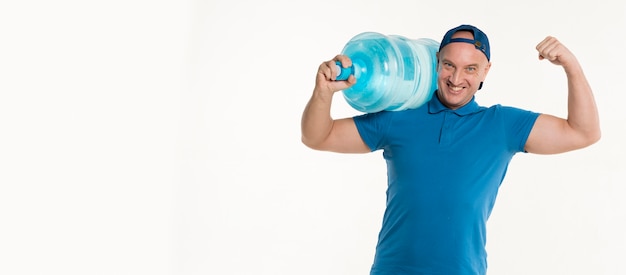 Foto gratuita repartidor con botella de agua y mostrando bíceps