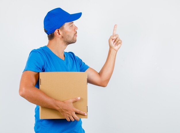 Repartidor con caja de cartón con el dedo hacia arriba en camiseta azul