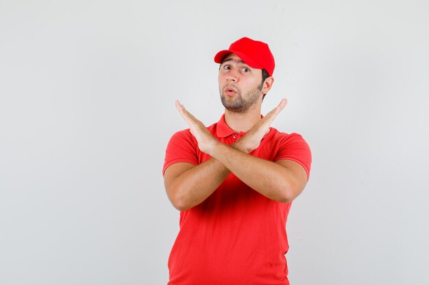Repartidor en camiseta roja, gorra sin gesto