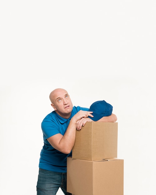 Foto gratuita repartidor cansado descansando sobre cajas de cartón