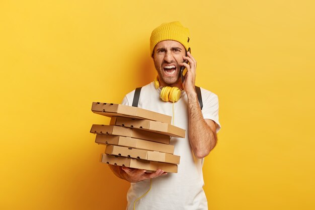 Repartidor irritado con cajas de pizza