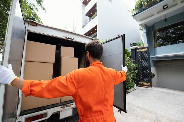 Repartidor joven cerrando las puertas del camión de reparto