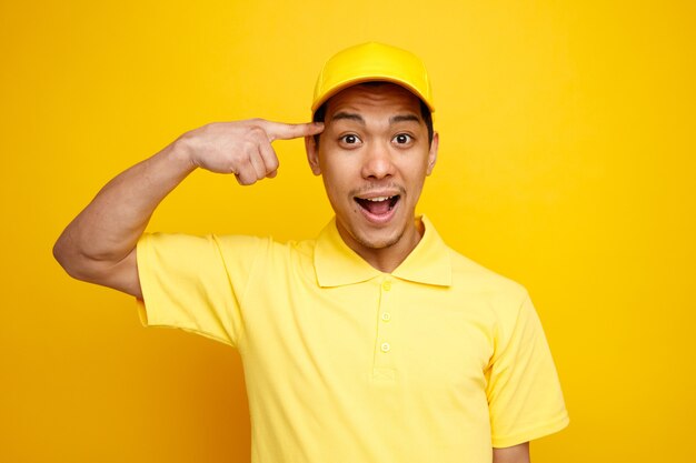 Repartidor joven emocionado con gorra y uniforme haciendo gesto de pensar