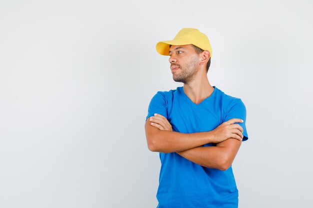 Repartidor mirando a un lado con los brazos cruzados en camiseta azul