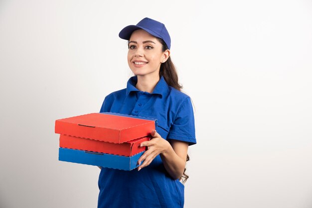Repartidor profesional vistiendo uniforme azul entrega pizza. Foto de alta calidad