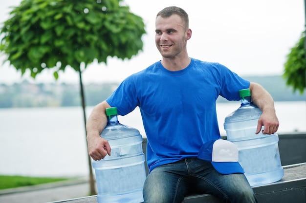 Repartidor sentado con botellas de agua al aire libre