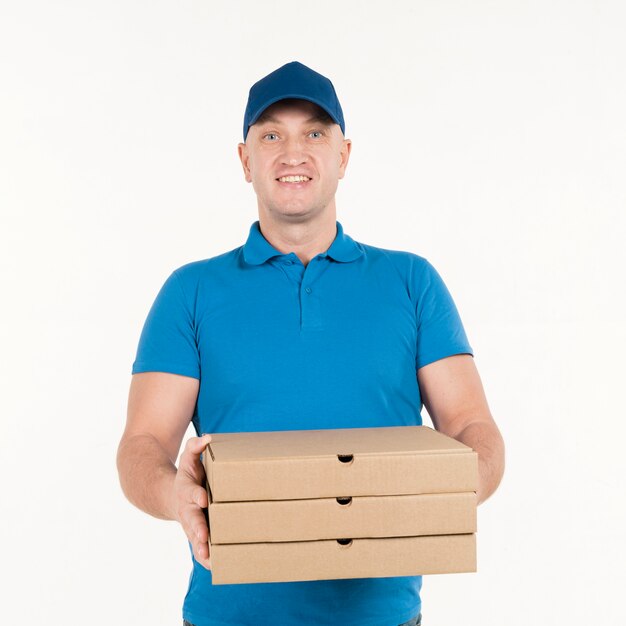 Repartidor sonriendo mientras sostiene cajas de pizza
