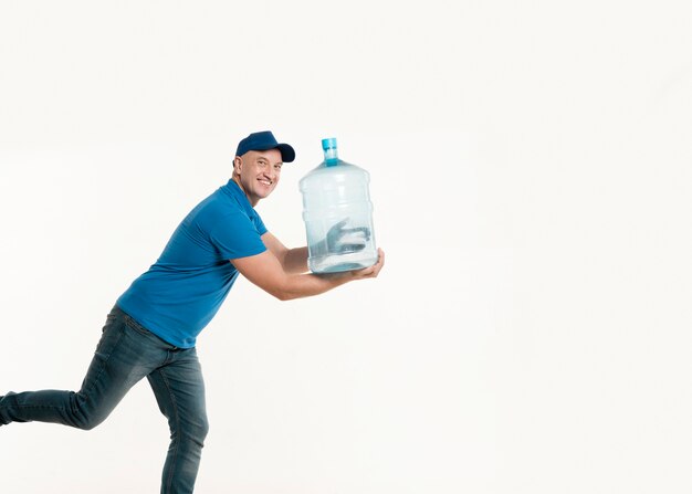 Repartidor sonriendo y posando con una botella de agua