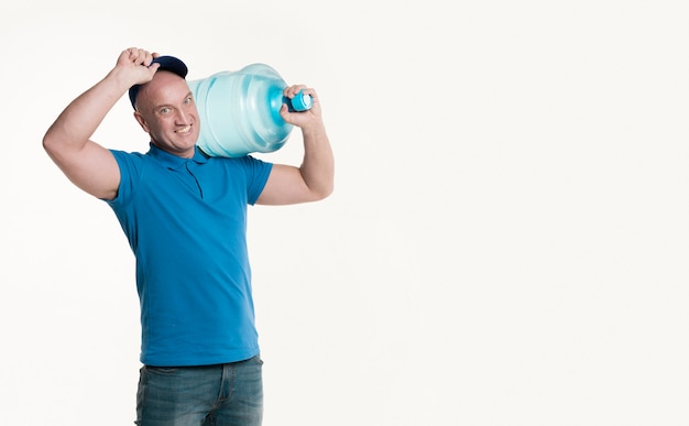 Foto gratuita repartidor sonriente con botella de agua y tapa