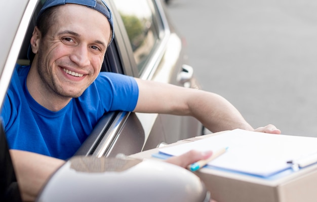 Foto gratuita repartidor sonriente en coche