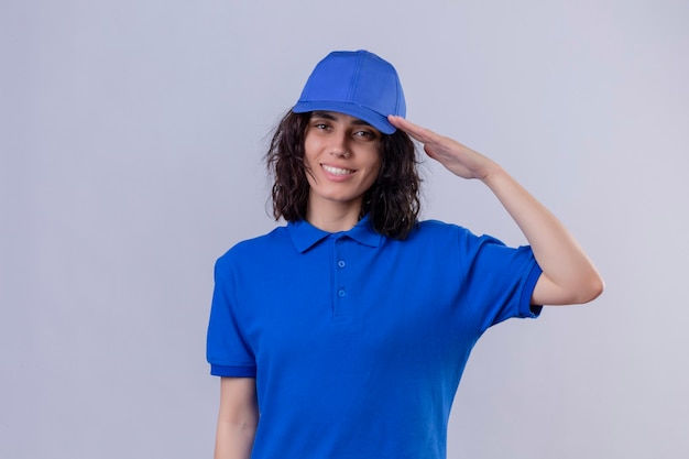 Foto gratuita repartidora en uniforme azul y gorra saludando sonriendo amable sobre espacio en blanco aislado