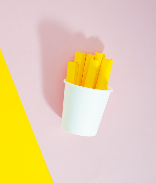 Foto gratuita réplica de papas fritas sobre fondo rosa