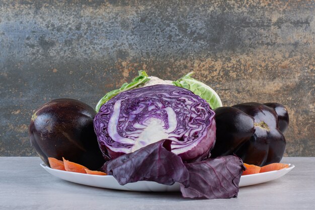 Repollo, coliflor, berenjenas en un plato blanco. Foto de alta calidad