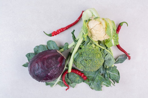Repollo, coliflor y verduras sobre superficie blanca