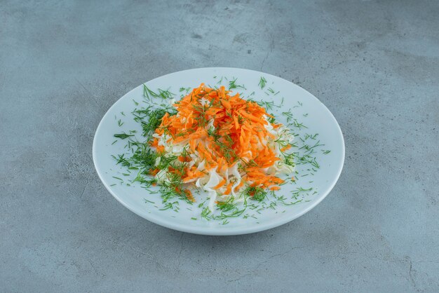 Repollo picado y zanahorias en un plato blanco.