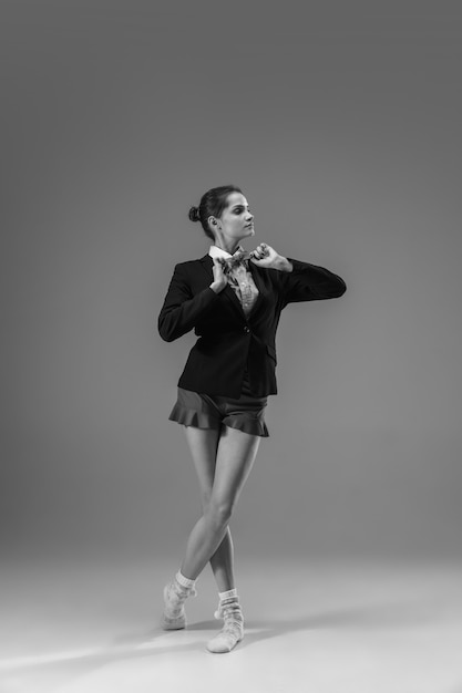 Reporte. Joven mujer de moda y elegante con chaqueta y calcetines trabajando desde casa. Mitad de estilo comercial y mitad hogareño. En blanco y negro.