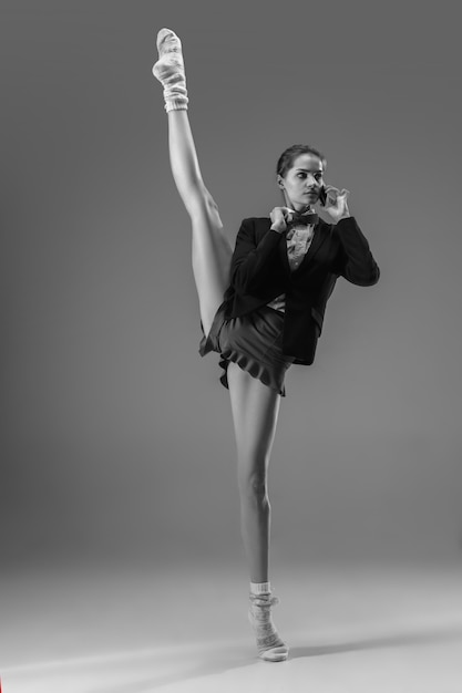 Reporte. Joven mujer de moda y elegante con chaqueta y calcetines trabajando desde casa. Mitad de estilo comercial y mitad hogareño. En blanco y negro.