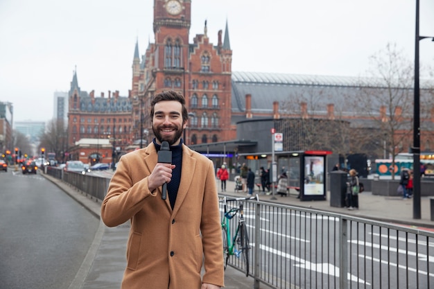 Reportero sonriente de tiro medio en el reino unido