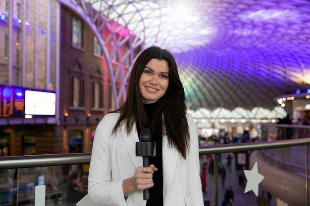 Reportero sonriente de tiro medio