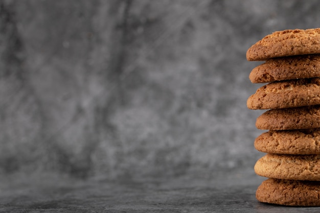 Foto gratuita una reserva de galletas de avena sobre hormigón gris.