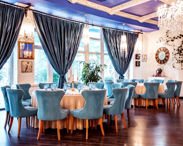 Restaurante hall con sillas azules y decoraciones en la pared.