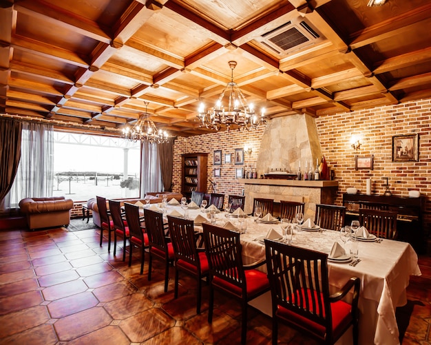 Restaurante salón privado con mesa para 14 personas, techo de madera, paredes de ladrillo y chimenea.