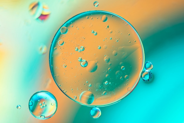 Resumen aceite gotas en líquido sobre fondo muticolored borrosa