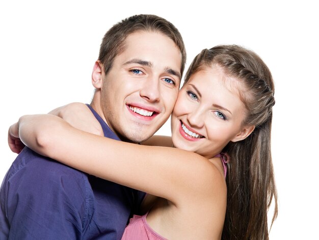 Retrato de abrazar joven hermosa pareja feliz - pared blanca