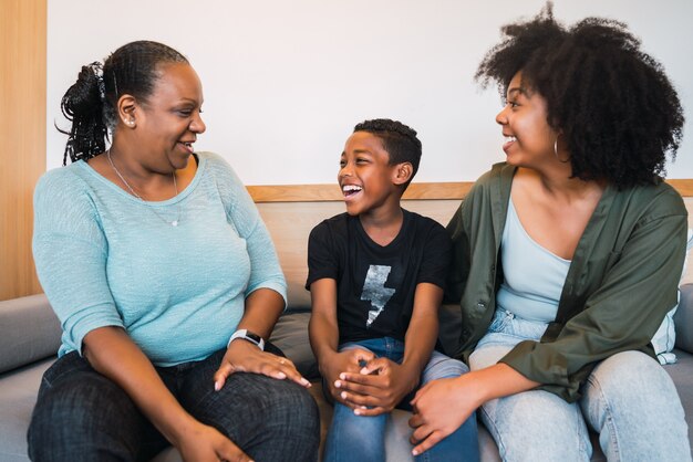 Retrato de abuela afroamericana, madre e hijo pasar buen rato juntos en casa. Concepto de familia y estilo de vida.