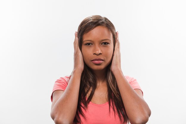 Retrato de una adolescente africana cubriendo sus orejas