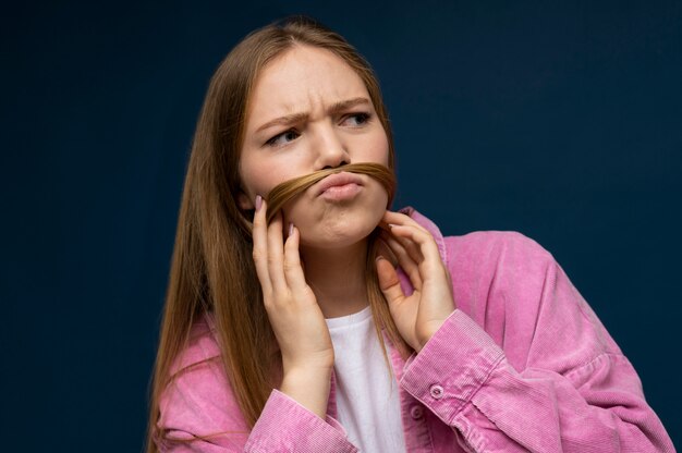 Retrato de una adolescente con un falso bigote hecho con su cabello