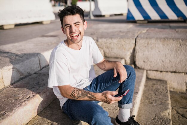 Retrato de un adolescente feliz con su teléfono celular