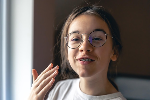 Foto gratuita retrato de una adolescente con gafas y aparatos ortopédicos