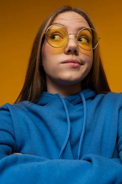 Retrato de una adolescente con gafas de sol y mirando algo sospechoso