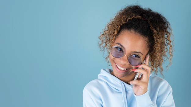 Retrato de una adolescente con gafas de sol y con smartphone
