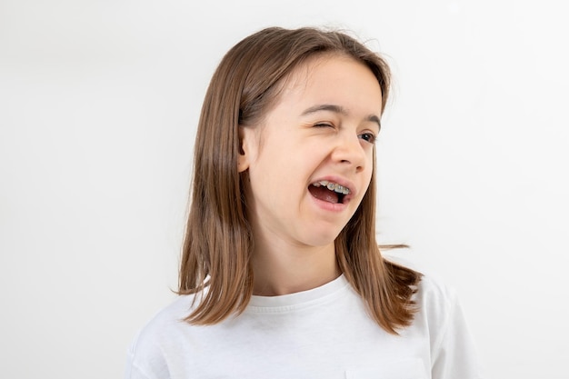 Foto gratuita retrato de una adolescente guiñando el ojo alegremente sobre un fondo blanco aislado