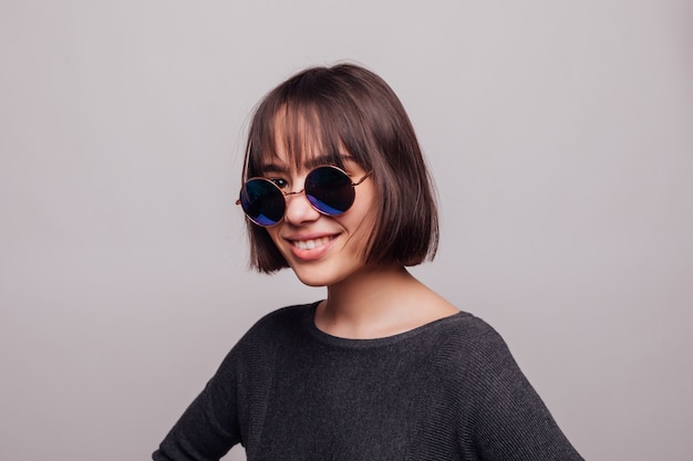 Retrato de adolescente niña bonita en gafas de sol aisladas.