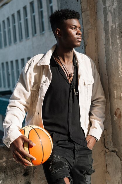 Retrato de adolescente posando con pelota de baloncesto