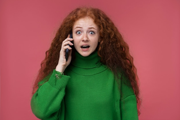 Foto gratuita retrato de una adolescente que parece sorprendida mientras habla por teléfono