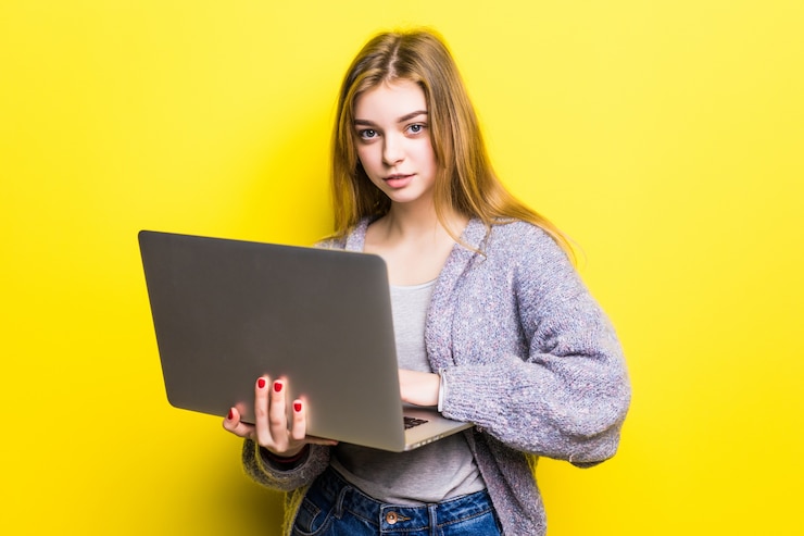 Foto gratuito retrato de una adolescente sonriente sosteniendo el ordenador portátil