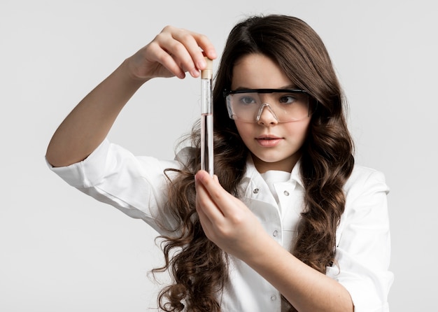 Foto gratuita retrato de adorable joven científico comprobación de muestra de química