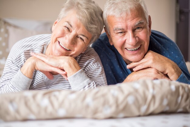 Retrato de adultos mayores alegres en el dormitorio